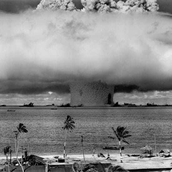 grayscale photo of explosion on the beach