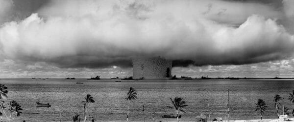 grayscale photo of explosion on the beach