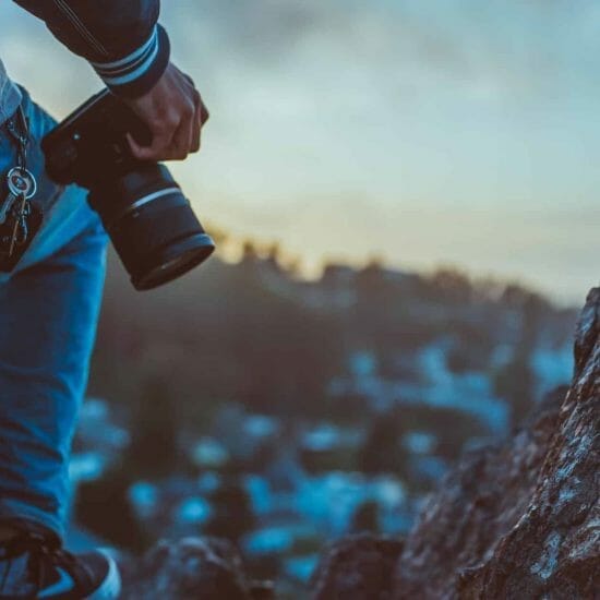 person holding black dslr camera