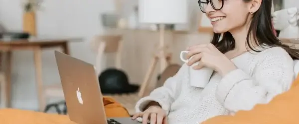 woman having coffee while using laptop