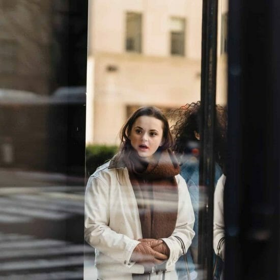 amazed woman standing near glass showcase of store