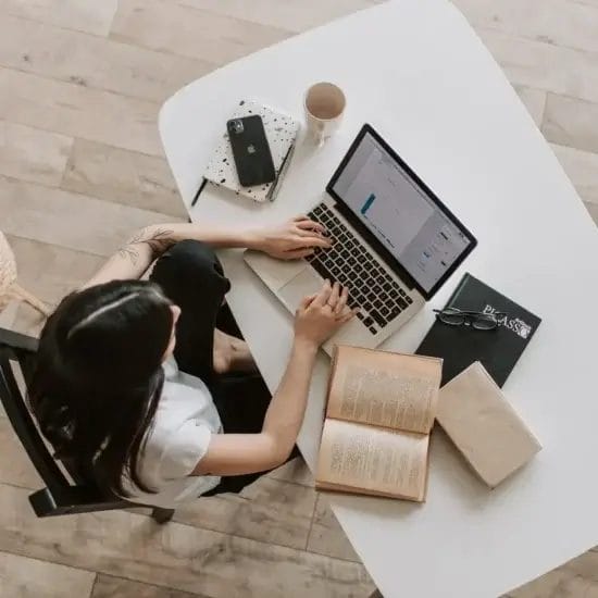 young lady typing on keyboard of laptop in living room