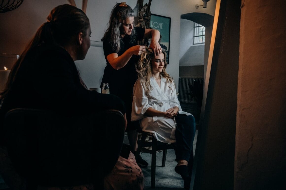 hairstylist fixing her client s hair