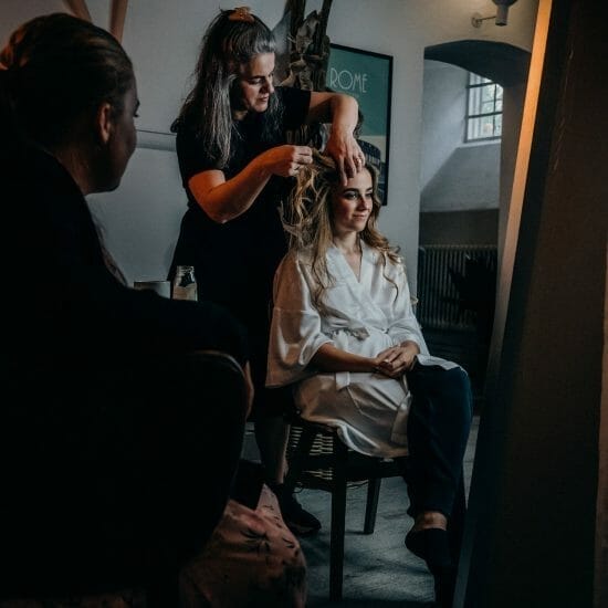 hairstylist fixing her client s hair