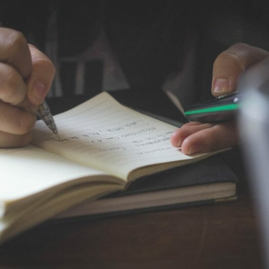 person writing while using phone