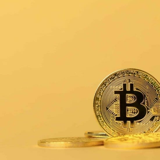 Gold bitcoin cryptocurrency coins on yellow backgound