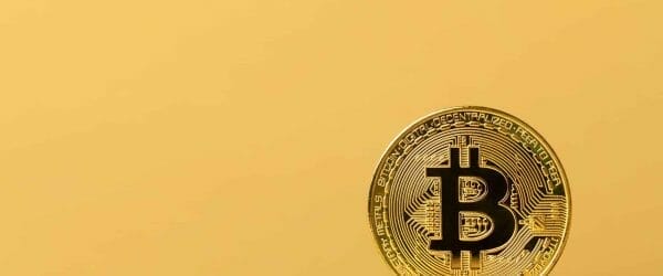 Gold bitcoin cryptocurrency coins on yellow backgound