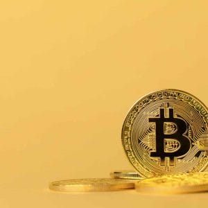 Gold bitcoin cryptocurrency coins on yellow backgound