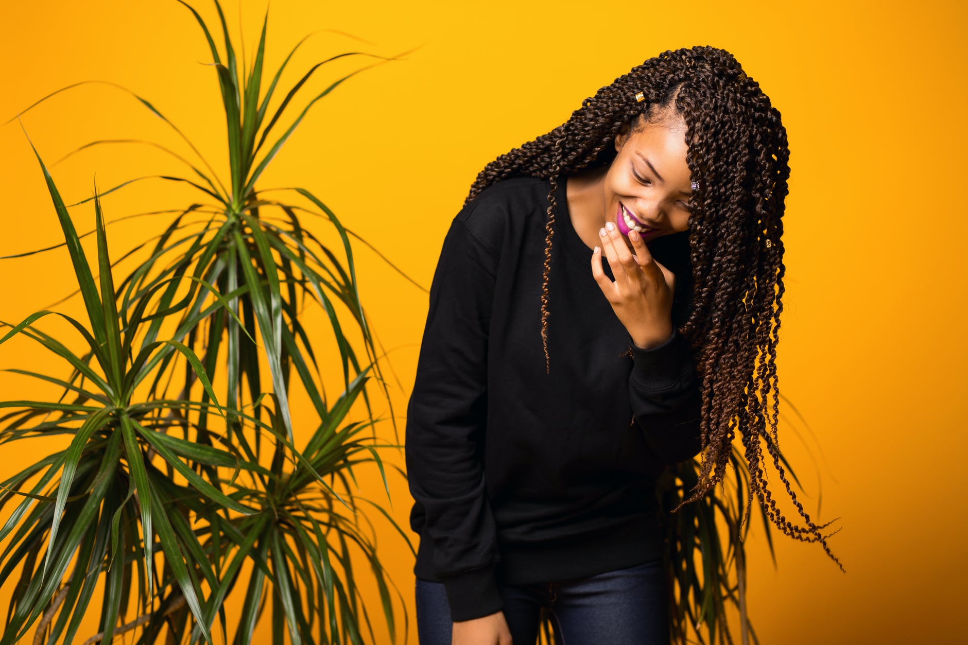 optimistic young black female having fun in yellow studio