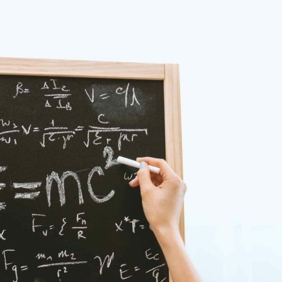 person holding a chalk in front of the chalk board