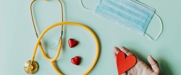 medical stethoscope and mask composed with red foiled chocolate hearts