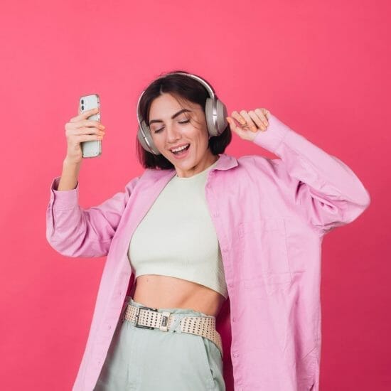 happy positive woman headphones pink red wall