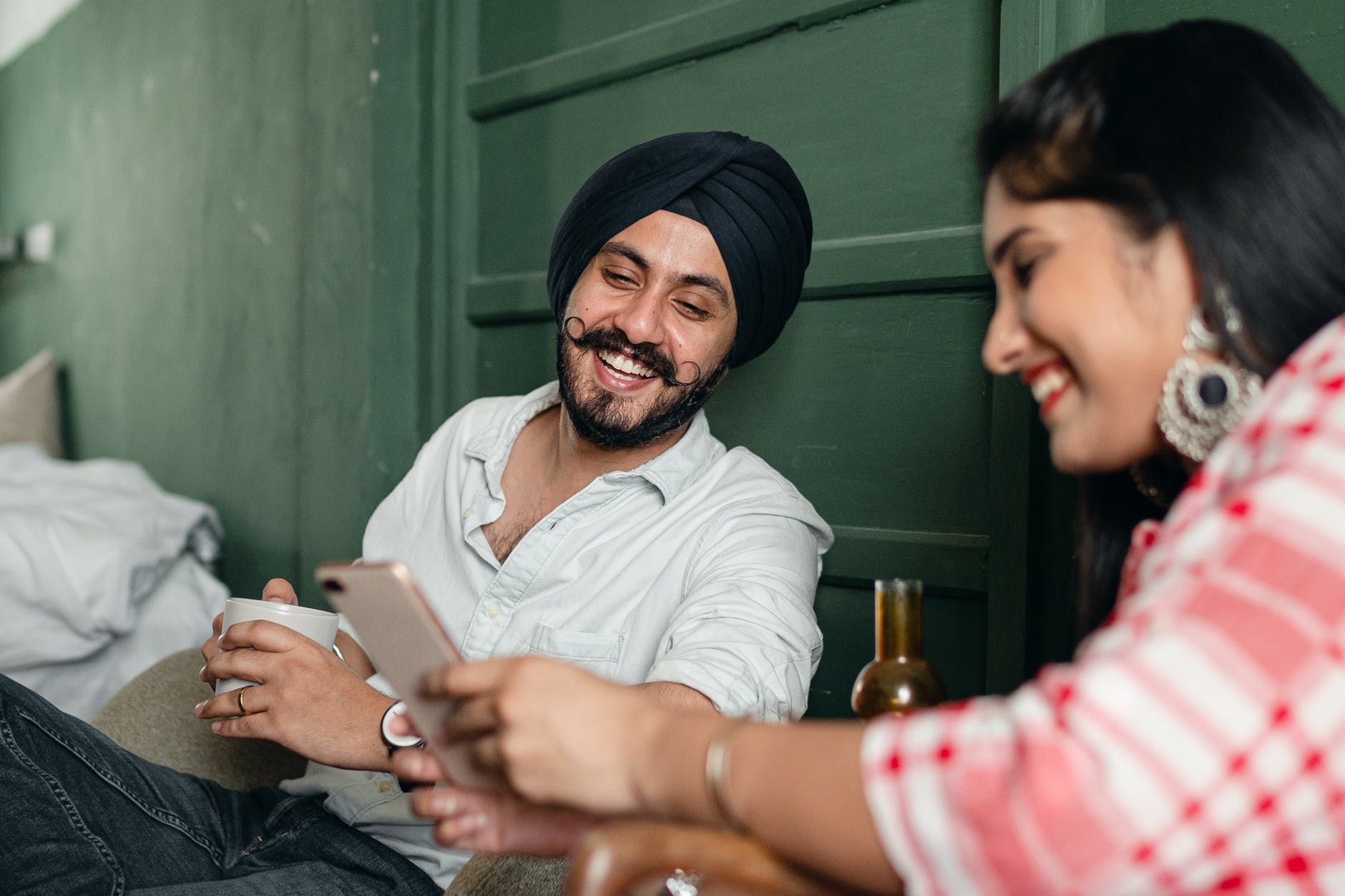 expressive happy couple surfing smartphone and laughing about social media and seo