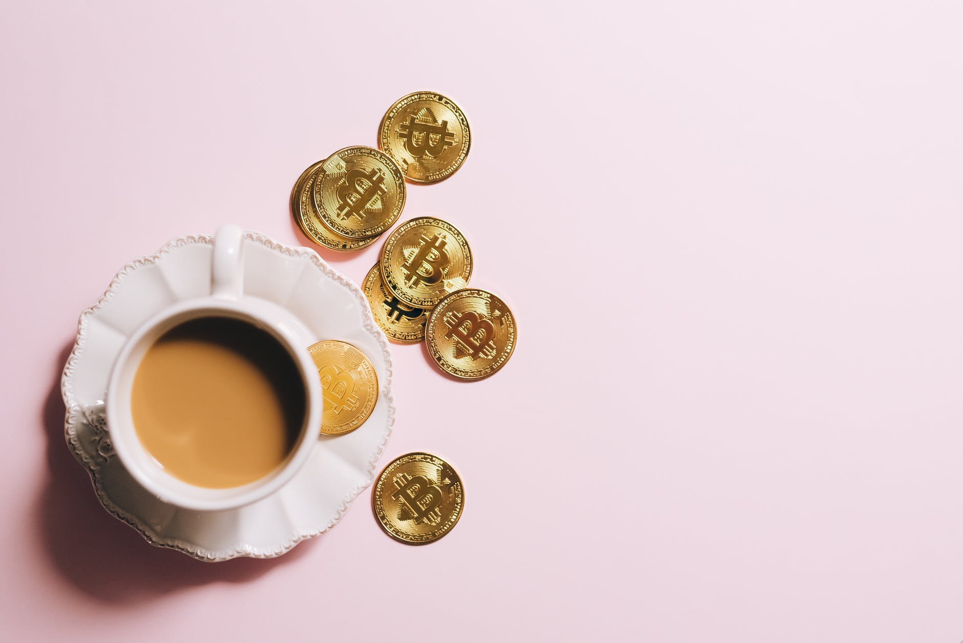 white ceramic cup with saucer and gold round coins