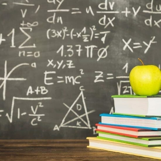 books with alarm clock near blackboard