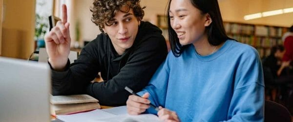 a man and a woman sitting in a library