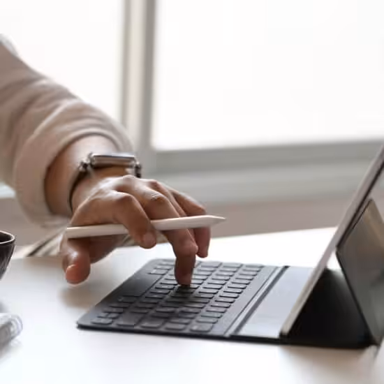 Person typing on tablet with coffee