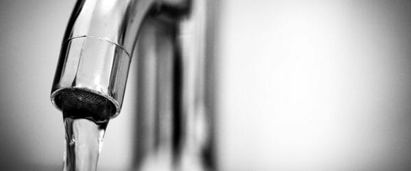 macro photography of a stainless steel faucet