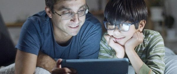 father and son looking at tablet screen