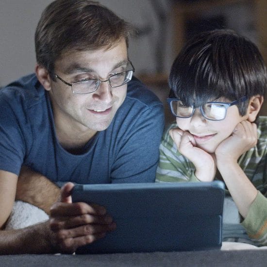 father and son looking at tablet screen
