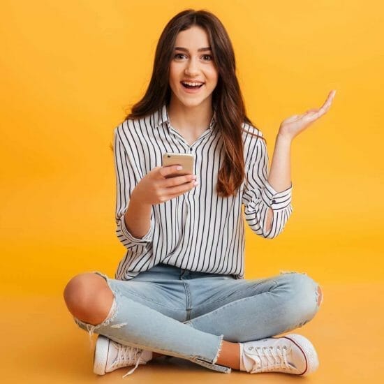 portrait excited young girl holding mobile phone