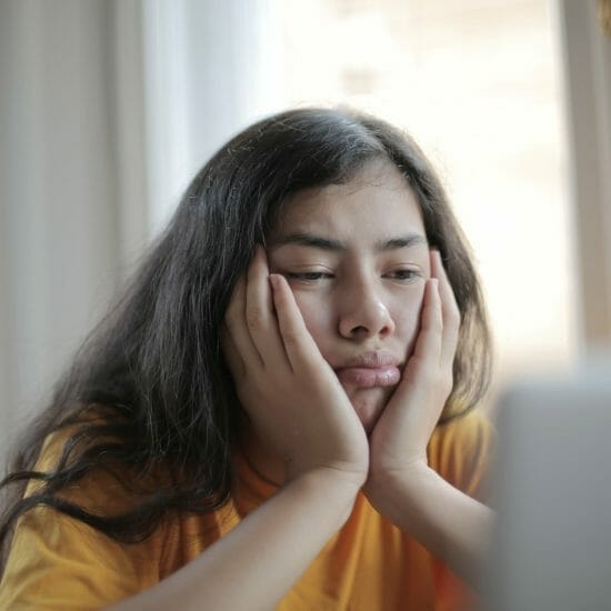 melancholic woman watching video on laptop at home