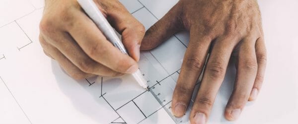 close up photo of person drawing lines on paper with ruler and pen