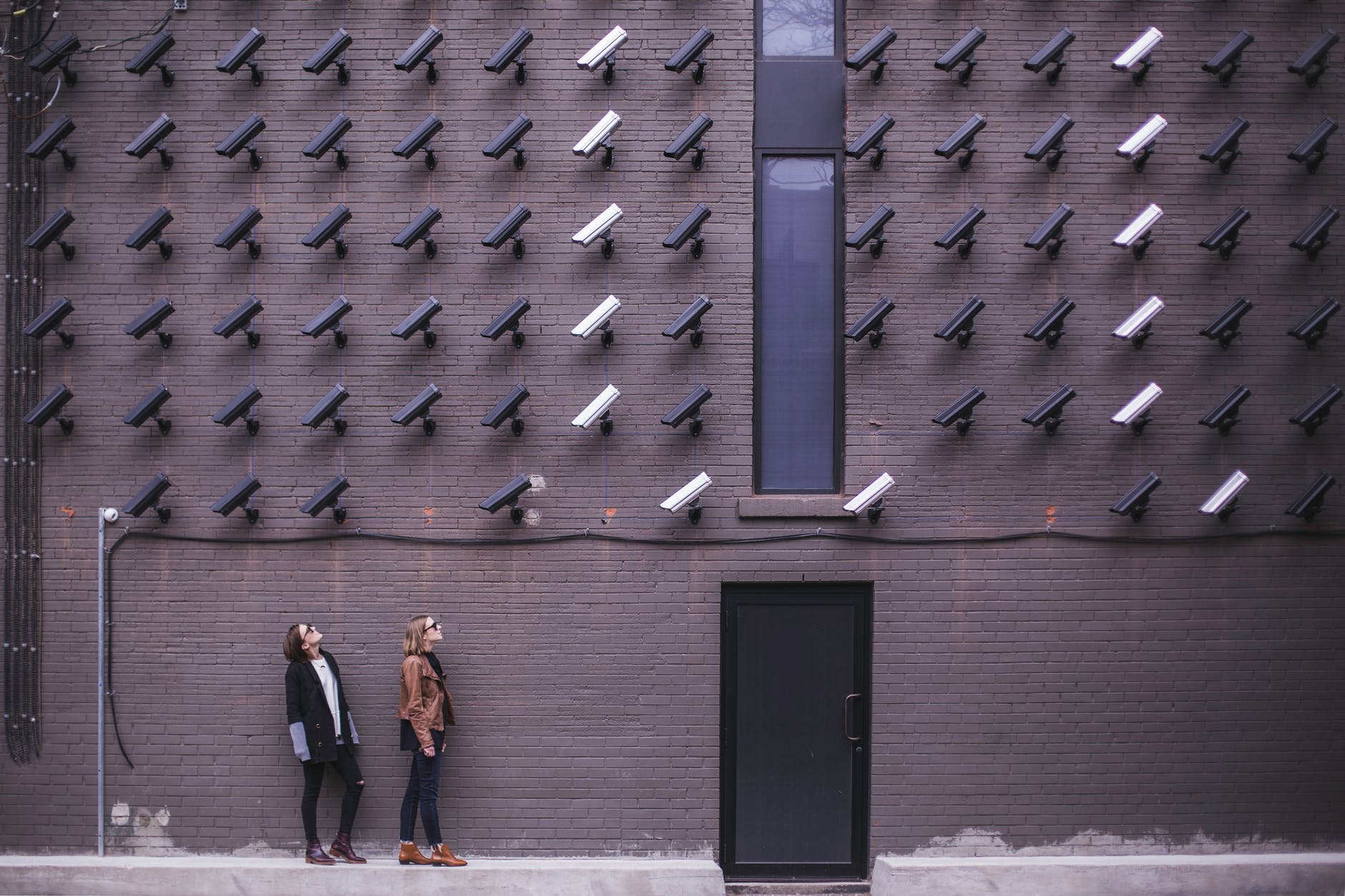 two person standing under lot of bullet cctv camera - The Digital Privacy Survey