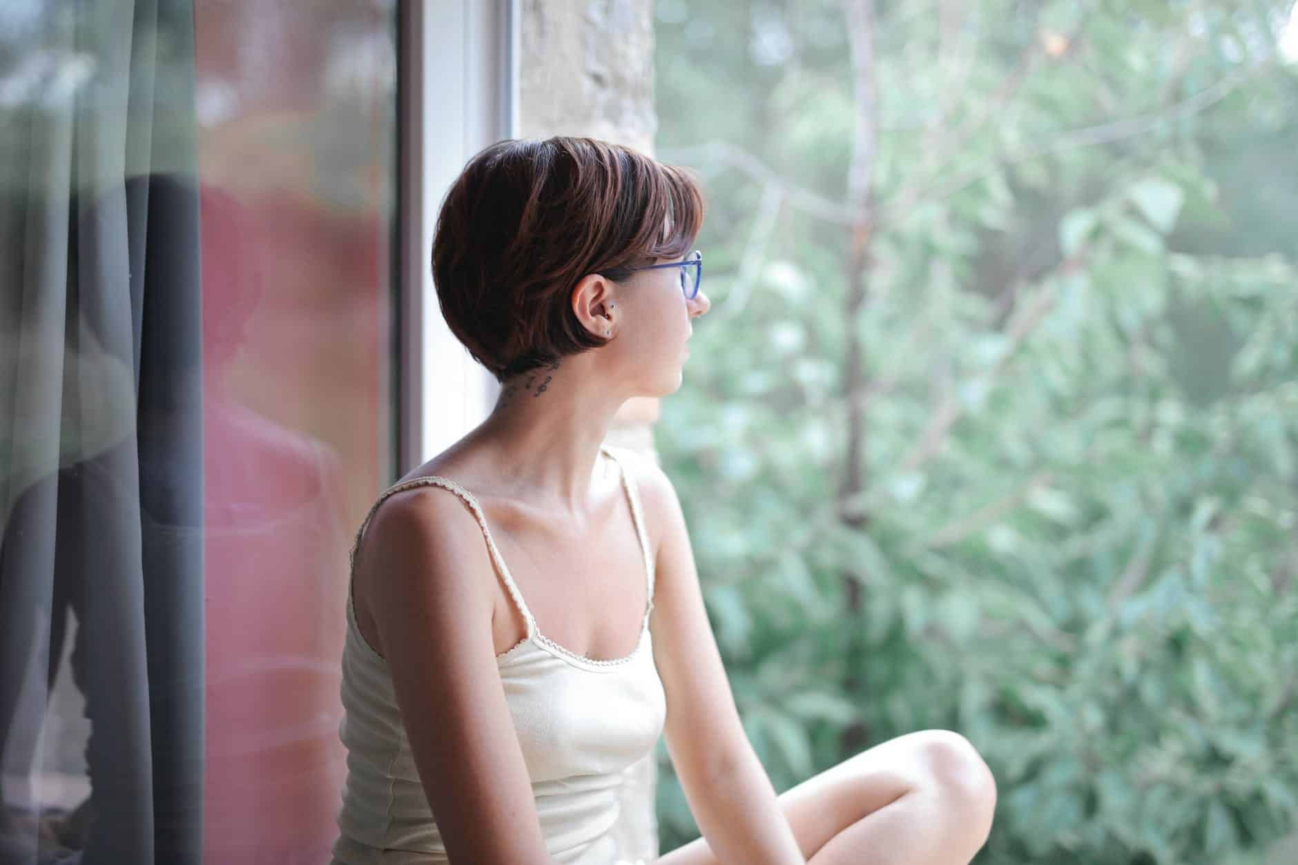 pensive woman looking at window