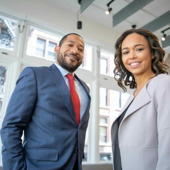 man and woman smiling inside building