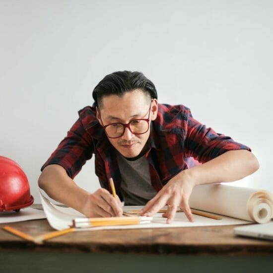 focused architect drawing on paper in studio