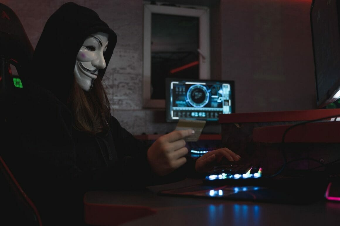 woman in black hoodie holding a bank card showing cybersecurity