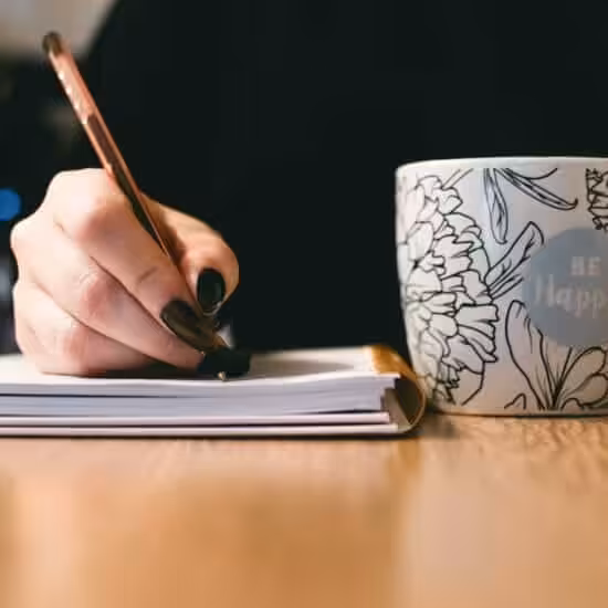 person holding white ceramci be happy painted mug