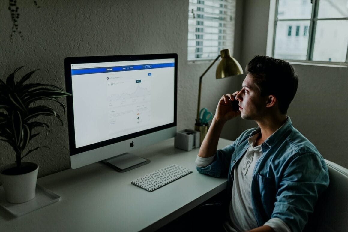 man in blue denim jacket facing turned on monitor looking for 10 Best Blockchain Courses