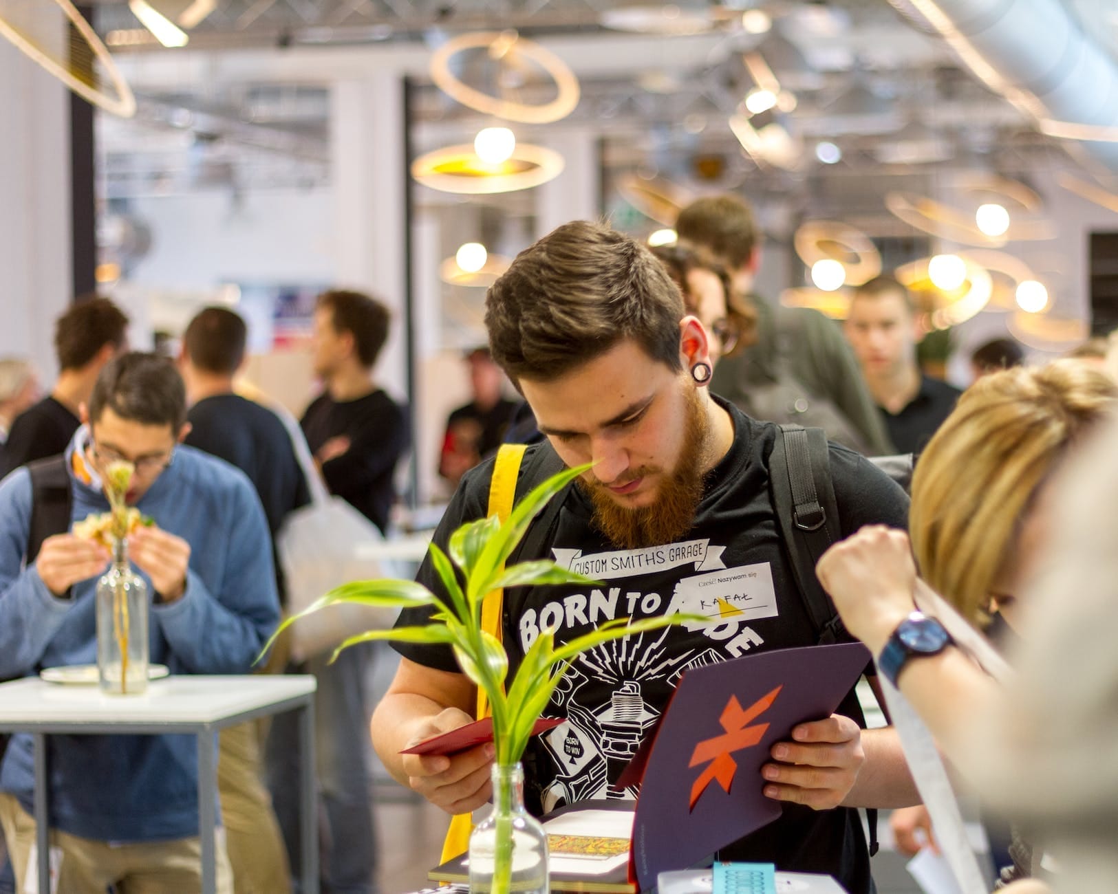 men wearing black shirt holding a purple book at an event for event monetization