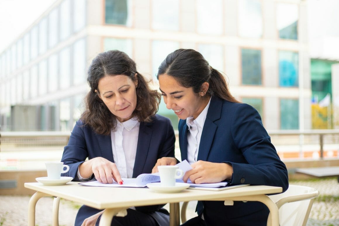 businesswomen working with documents outdoor cafe