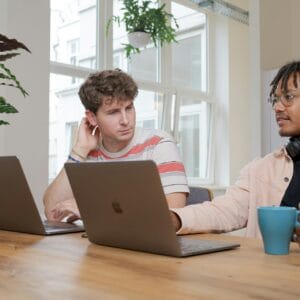 Two people working on laptops