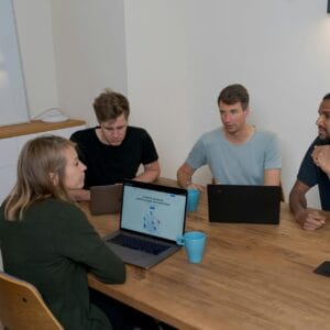 Team collaborating over laptops in meeting.