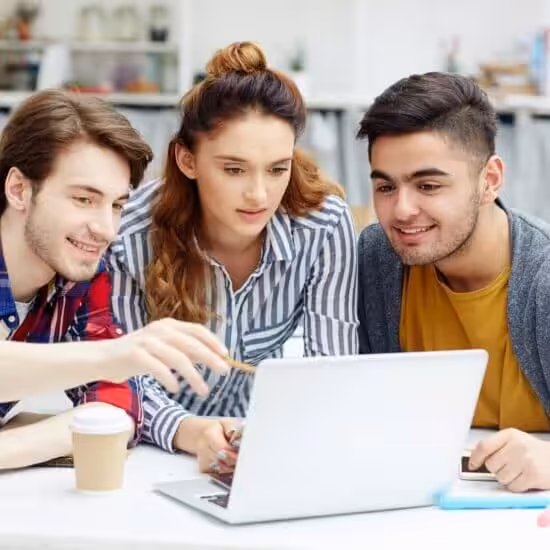 Three students collaborating on laptop