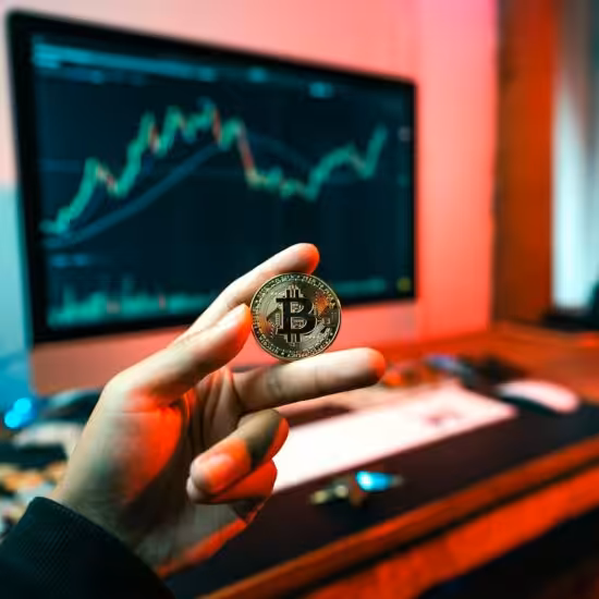 a person holding a coin in front of a computer